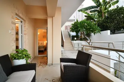a balcony with chairs and plants on a building at Favola Golden Beach Villa in Daratso