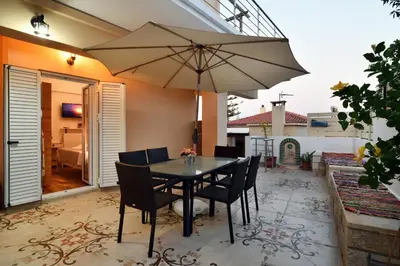 a table with chairs and an umbrella on a patio at Favola Golden Beach Villa in Daratso