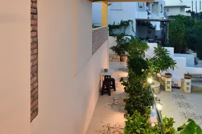 a balcony with plants and a white building at Favola Golden Beach Villa in Daratso