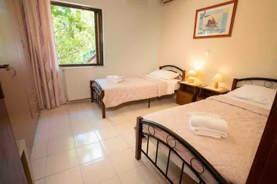 a small bedroom with two beds and a window at Villa Marianna Lygides in Ayiá