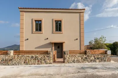 a small house with a stone wall at Villa Elpida in Myloniana in Milonianá