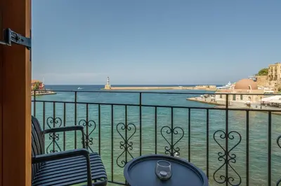 a balcony with two chairs and a view of the water at Leo Apartment 2 bdr apt overlooking the harbor in Chania Town