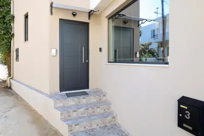 a black door on the side of a house at Villa Cicada Chania, steps from the beach, Car included in Agia Marina Nea Kydonias