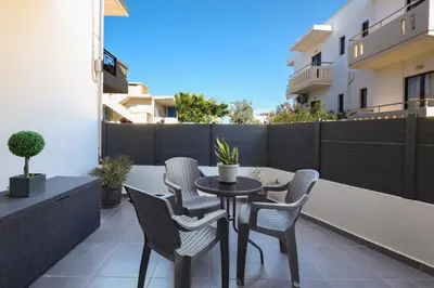 a patio with a table and chairs on a balcony at Villa Cicada Chania, steps from the beach, Car included in Agia Marina Nea Kydonias