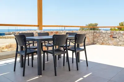 a table and chairs on a patio with a view at Meli apartments Paleochora in Palaiochóra