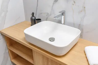 a white sink on a wooden counter in a bathroom at Meli apartments Paleochora in Palaiochóra