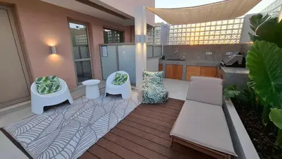 a patio with two white chairs and a table at Luxious Holiday Apt in Chania Town