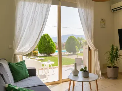 a living room with a couch and a sliding glass door at Cisterna Apartment - Shared Pool in Stérnai