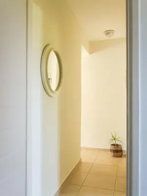 a hallway with a round mirror on the wall at Cisterna Apartment - Shared Pool in Stérnai