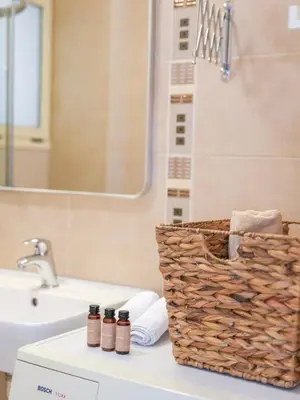a bathroom with a sink and a basket on a counter at Cisterna Apartment - Shared Pool in Stérnai