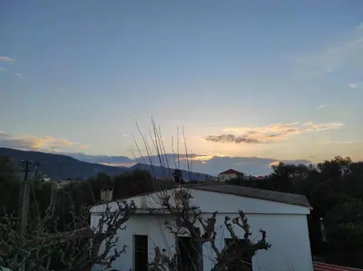 a white building with the sunset in the background at Natura Calma - Private Estate in Chania Town