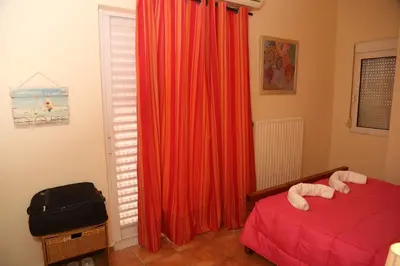 a bedroom with a red curtain and a bed and a window at THE VERANDA OF CHANIA in Chania Town