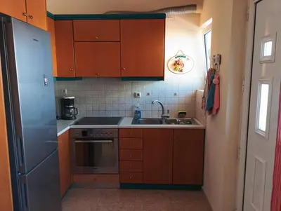 a kitchen with wooden cabinets and a sink at THE VERANDA OF CHANIA in Chania Town