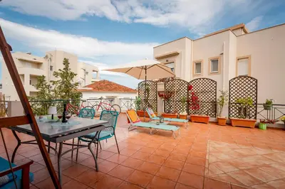 a patio with chairs and tables and an umbrella at THE VERANDA OF CHANIA in Chania Town