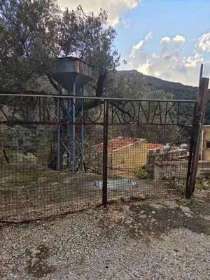 an iron fence with a water tower in the background at Κρητικό Σπίτι Στον Παράδεισο in Palaiochóra