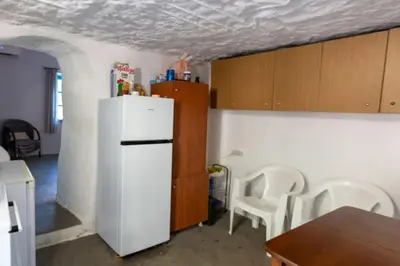 a kitchen with a white refrigerator and wooden cabinets at Κρητικό Σπίτι Στον Παράδεισο in Palaiochóra