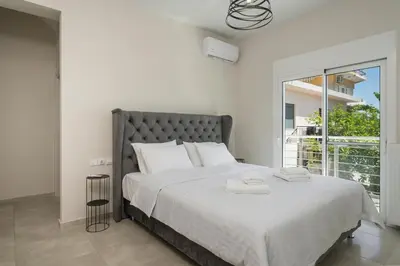 a bedroom with a large bed and a large window at Ardian's home in Chania Town
