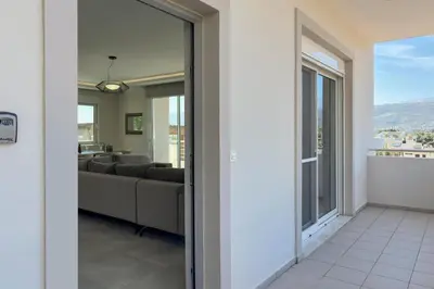 a living room with a couch and a large window at Ardian's home in Chania Town