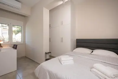 a white bedroom with a bed with towels on it at Ardian's home in Chania Town