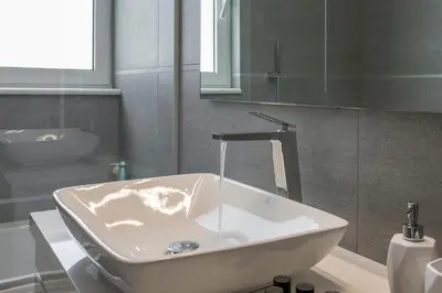 a bathroom with a white sink and a mirror at Ardian's home in Chania Town