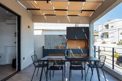 a dining area with a table and chairs on a balcony at Ikon Living Chania in Chania Town