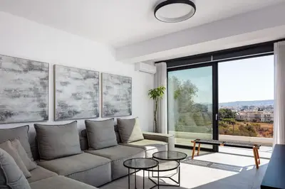 a living room with a couch and a large window at Ikon Living Chania in Chania Town