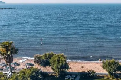a beach with palm trees and the ocean at Astrinos Apartment Simple cozy comfortable close to the beach in Chania Town