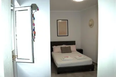 a bedroom with a bed and a window and a door at Astrinos Apartment Simple cozy comfortable close to the beach in Chania Town