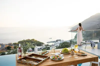 a table with food and wine on top of a balcony at Villa Dóma in Sfakiá
