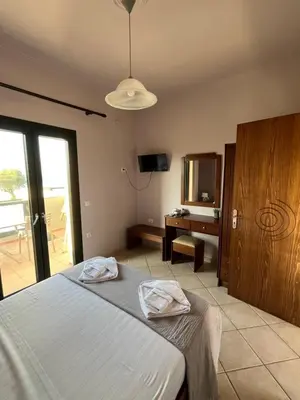 a bedroom with a bed and a desk and a mirror at Girogiali Apt 3 in Kamára