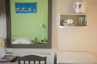 a mirror in a room with a table and a chair at Nereides Hotel in Kolymvari