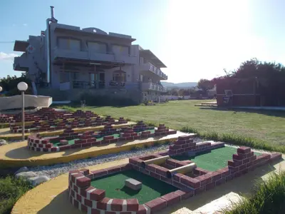 a garden with bricks and grass in front of a building at Nereides Hotel in Kolymvari