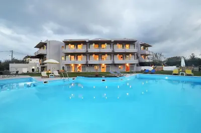 a large building with a large swimming pool in front of it at Nereides Hotel in Kolymvari
