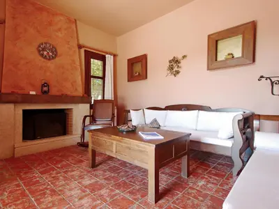 a living room with a white couch and a fireplace at Villa Galania Armeni Crete in Arménoi