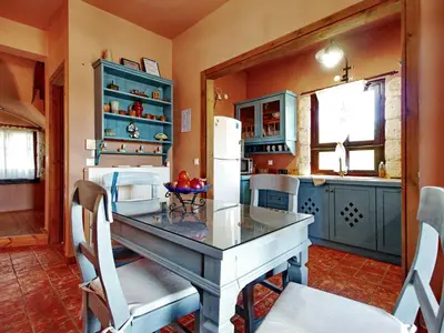 a kitchen with a table and a refrigerator at Villa Galania Armeni Crete in Arménoi