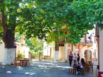 a group of people walking down a street under a tree at Villa Galania Armeni Crete in Arménoi