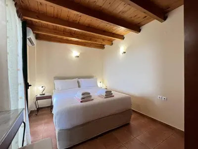 a bedroom with a bed and a wooden ceiling at Villa Artemis Vryses Crete in Alikampos