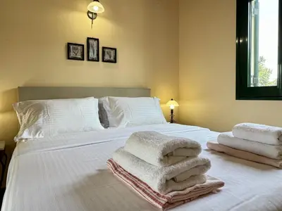 a bedroom with a white bed with towels on it at Villa Artemis Vryses Crete in Alikampos