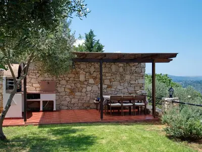 a gazebo with a table and chairs in a yard at Villa Artemis Vryses Crete in Alikampos