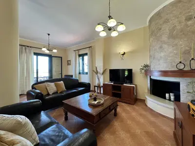 a living room with a couch and a fireplace at Villa Artemis Vryses Crete in Alikampos