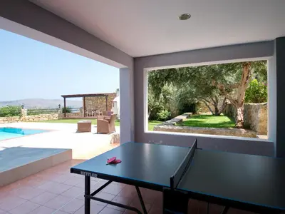 a table in a room with a view of a pool at Villa Avra Vrisses Crete in Alikampos