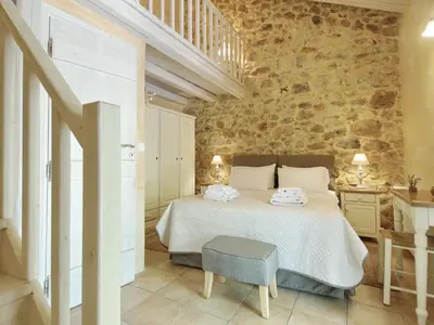 a bedroom with a bed and a stone wall at Villa Vigla in Samonás