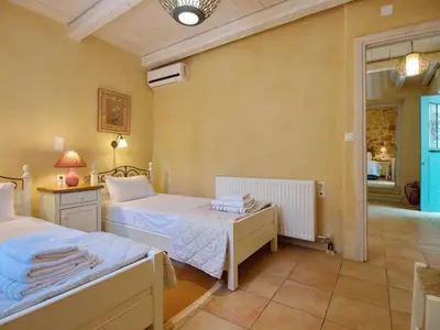a bedroom with two beds and a hallway at Villa Vigla in Samonás