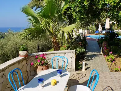 a table and chairs on a patio next to a pool at Villa Clio with Pool Stalos Crete in Stalos