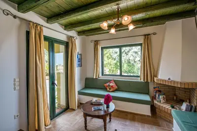 a living room with a green couch and a table at Villa Panos in Stalos in Stalos