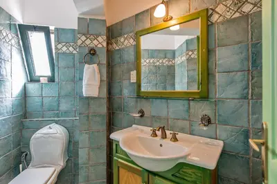 a bathroom with a sink and a toilet and a mirror at Villa Panos in Stalos in Stalos