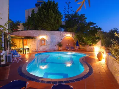 a swimming pool in a backyard at night at Villa Panos in Stalos in Stalos
