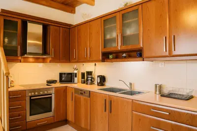 a kitchen with wooden cabinets and a sink at Viva Elafonisi - Studios or Apartment, 10min to Elafonissi in Plokamianá