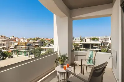 a balcony with two chairs and a table with a view at Afrodite-Μεζονέτα στην πόλη Χανιά in Chania Town
