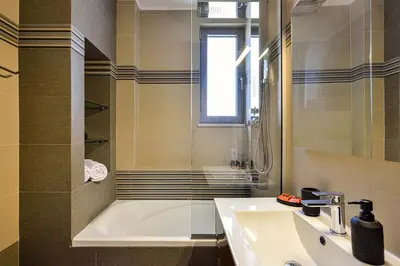 a bathroom with a tub and a sink and a shower at Ionia Cozy Home in Chania Town